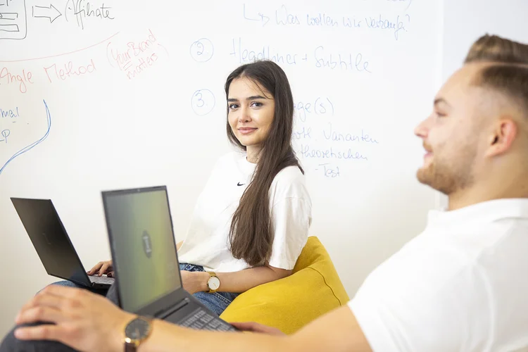 Zwei Studenten mit Laptops in Uni